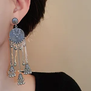 Close-up of vintage ethnic style long tassel earrings with ornate bell details