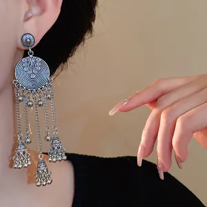 Detailed macro view of vintage ethnic silver tassel earrings with delicate bell drops