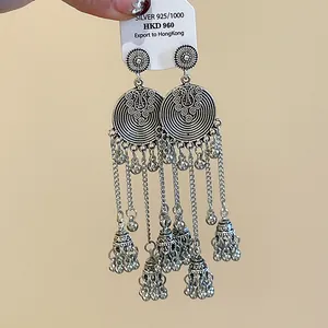 Close-up of vintage silver ethnic tassel earrings with round bells and chains