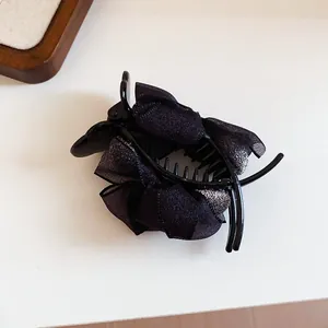 Detailed macro view of elegant French style black ribbon bow hair claw clip accessory