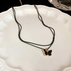 Elegante schwarze zweireihige Perlenkette mit blauem Schmetterlingsanhänger