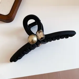 Elegant matte black hair claw clip with golden pearl and faceted crystal detail