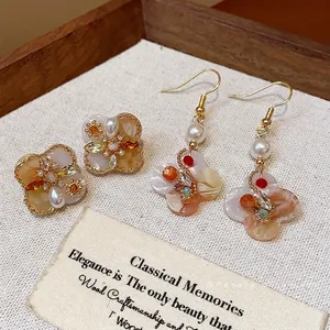 Elegant vintage 18K gold plated flower earrings with pearls and zircons in a wooden tray