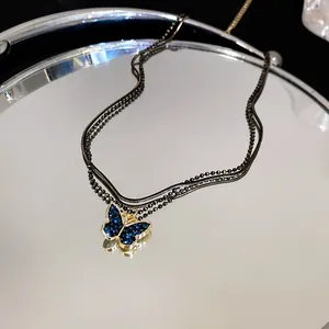 Detailansicht einer schwarzen doppellagigen Kette mit blauem Kristallschmetterling