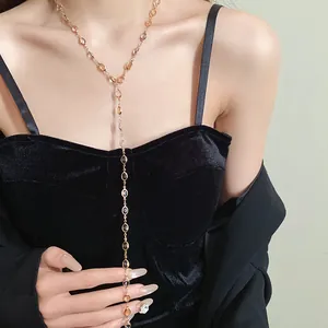 Close-up detail of a vintage resin oval tassel necklace on a black velvet dress