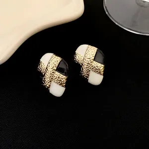 Gros plan de boucles d'oreilles vintage plaquées or avec détails en émail noir et blanc