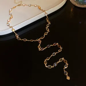 Detail view of retro gold-toned resin oval stone tassel necklace with heart charm