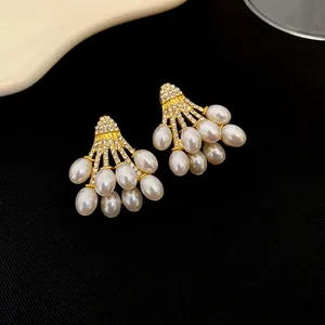Gros plan de boucles d'oreilles vintage dorées avec perles et cristaux brillants.