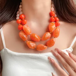 Nahaufnahme der kräftigen orangefarbenen Acrylperlen und Steine an einer Schichtkette