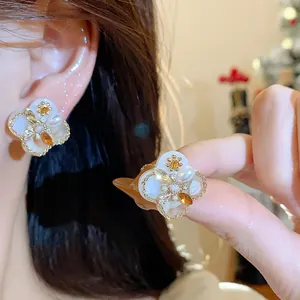 Detailed view of vintage 18K gold plated floral stud earrings with pearls and zircons