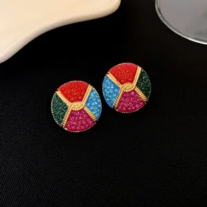 Gros plan de boucles d'oreilles vintage plaquées or avec strass multicolores pavés