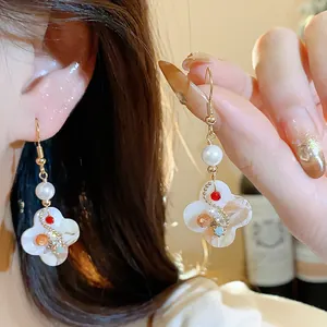 Detailed macro view of vintage 18K gold plated zircon flower earrings with elegant pearls.