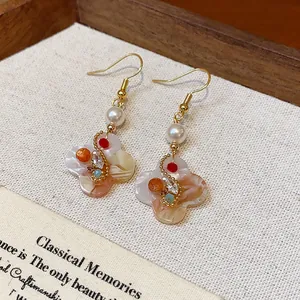 Detailed view of 18K gold plated vintage floral earrings with pearls and zircon