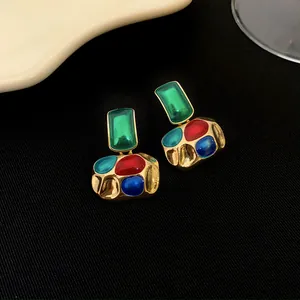 Vue détaillée de boucles d'oreilles vintage plaquées or avec pierres multicolores vibrantes
