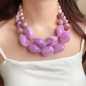 Nahaufnahme einer klobigen doppellagigen lila Acrylsteinkette am asiatischen Model