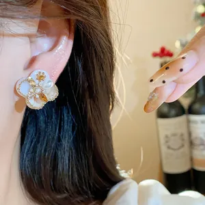Detail of 18K gold plated zircon flower pearl earring worn on the ear