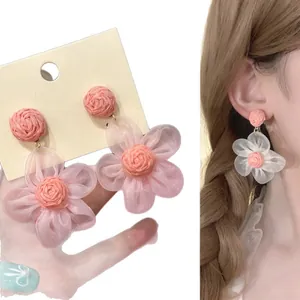 Elegantes pendientes de flores de rafia rosa con pétalos de tela transparente y estilo