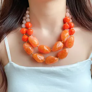 Detailansicht der marmorierten Textur dieser auffälligen orangefarbenen Acryl-Perlenkette