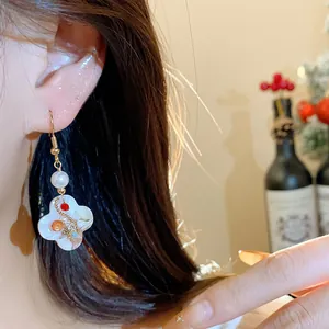 Macro detail of a vintage 18K gold plated flower earring with pearl and zircon