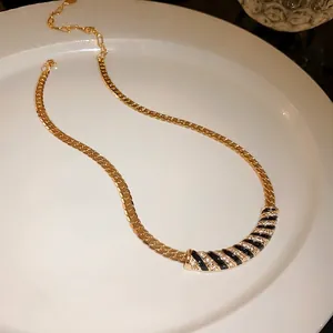 Vintage gold-plated necklace with black enamel stripes and shimmering rhinestones