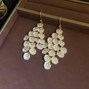 Elegant long drop earrings with white shell petals and sparkling zircons in a gold finish.