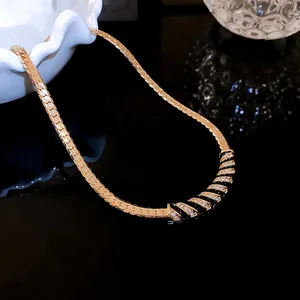 Close-up of gold-plated necklace with black enamel and sparkling rhinestones
