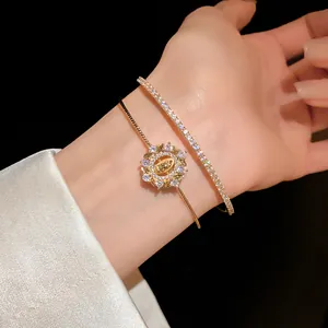 Primer plano de una elegante pulsera dorada de doble capa con dije de circón