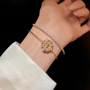 Vista detallada de la lujosa pulsera de doble capa de circón dorado en la muñeca.