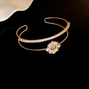 Primer plano detallado de un brazalete dorado de doble capa con lazo de circonitas