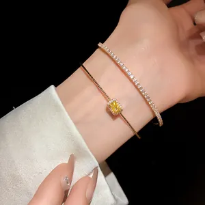 Elegante pulsera de doble capa en oro con circón amarillo rectangular y cadena tennis.