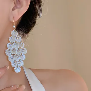 Macro view of elegant white shell tassel drop earrings featuring sparkling zircon accents