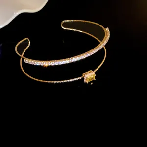 Vista de detalle de una pulsera dorada de doble capa con circón amarillo lujo