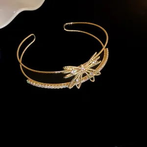 Vista detallada de un brazalete de lujo de doble capa en oro con lazo de circonitas brillantes