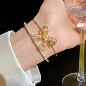Primer plano de una elegante pulsera dorada de doble capa con un diseño de lazo de circonita