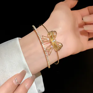 Primer plano de una elegante pulsera dorada de dos capas con lazo de circón brillante