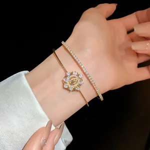 Vista detallada de una elegante pulsera de oro de dos capas con dijes de circonita