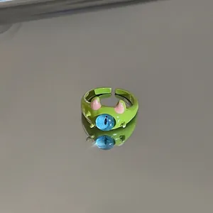 Close-up detail of a cute green monster adjustable ring with a unique large blue eye.