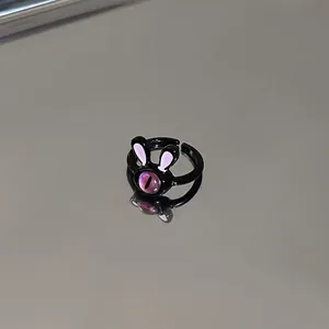Detailed view of the cute cartoon black rabbit ring featuring a unique purple cat-eye stone.