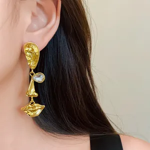 Macro view of unique abstract face gold earring with sparkling crystal eye detail