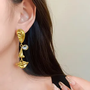 Detail of vintage palace style asymmetric face earrings with sparkling crystal eyes.