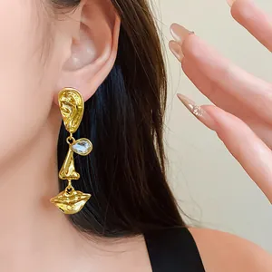 Artistic abstract face earrings with gold-plated finish and crystal accents for women.