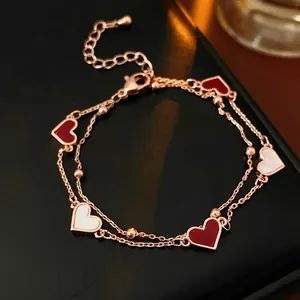 Bracelet double chaîne or rose avec cœurs en émail rouge et nacre blanche élégant.
