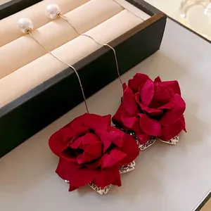 Elegant long drop earrings featuring red fabric roses and faux pearls on silver needles.