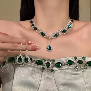 Close-up of vintage royal style jewelry set with emerald green waterdrop gemstones