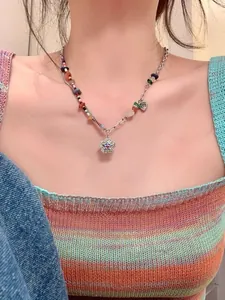 Nahaufnahme einer bunten Perlenkette mit Blumenanhänger und Herz-Charm-Detail