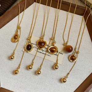 Close-up detail of retro Maillard style resin pendant necklaces in a wooden jewelry box