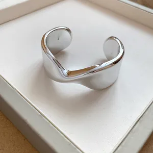 Detailed macro view of a shiny silver wavy cuff bracelet with modern geometric design