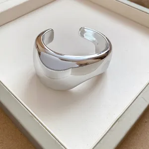 Close-up detail of a chunky silver-finish geometric cuff bracelet with wrinkled texture