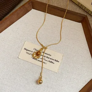 Close-up of vintage Maillard style gold necklace with oval resin pendant