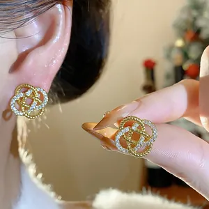 Vue détaillée d'élégantes boucles d'oreilles fleurs dorées avec zircons brillants